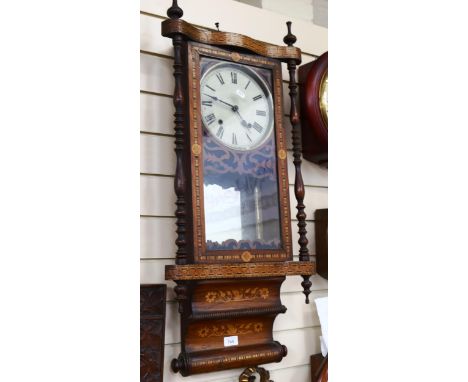 A wall clock in ornate marquetry decorated case, with turned spindles, height 85cm 