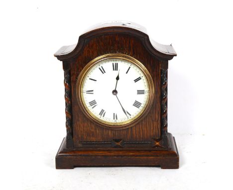 A small early 20th century oak-cased mantel clock, with barley twist supports, case height 19cm, working order, with key 