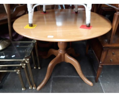 An Ercol light elm and beech pedestal dining table. 