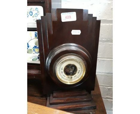 An Art Deco style barometer on stepped wooden stand, height 28cm. 