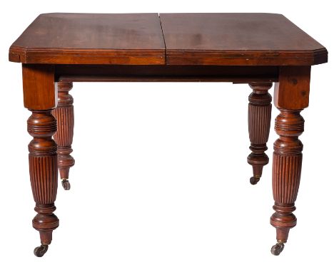A Victorian mahogany extending dining table, late 19th century; the top with moulded edges and canted corners, mechanically e
