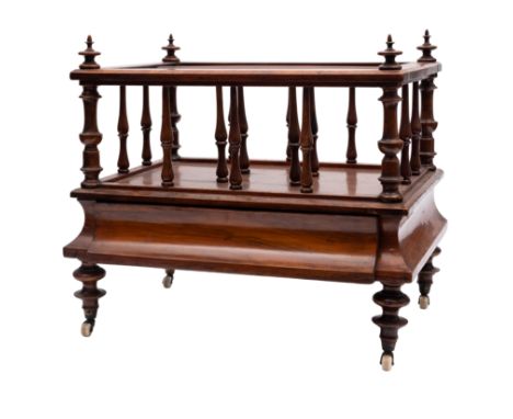 A Victorian walnut Canterbury, circa 1860; the openwork superstructure with turned spindle supports; the cavetto moulded base