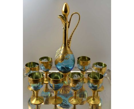 A 20TH CENTURY BOHEMIAN GLASS WINE DECANTER AND A SET OF EIGHT STEMMED GLASSES, blue tinted, heavily gilded and floral encrus