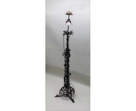 A FIRST QUARTER 20TH CENTURY BLACK FINISHED IRON WORK STANDARD LAMP, the scrolling frame having floral frond decoration, the 