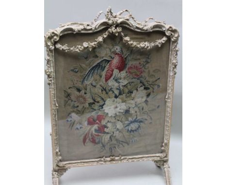 A 19TH CENTURY FIRESCREEN having glazed wool work panel depicting a parrot amongst floral foliage, the decorative plaster wor