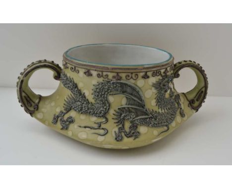 AN EARLY 20TH CENTURY JAPANESE CERAMIC TWO-HANDLED POT, bearing raised dragon decoration, on a green ground, bearing manufact