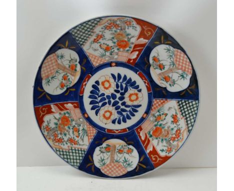 A JAPANESE IMARI CERAMIC CHARGER, painted and gilded with panels of flowers on a cobalt blue ground, 40cm in diameter 