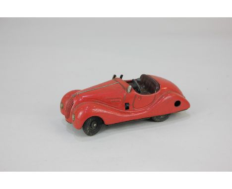 A Schuco clockwork tin plate mechanical toy motor car, Examico 4001, in red, play worn, no key