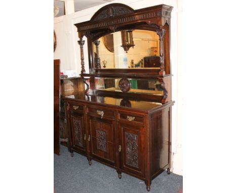 A Victorian style carved mahogany sideboard, with raised mirror back and shelf flanked by fluted column supports, an arrangem