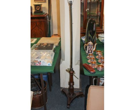 A 19th century rosewood fire screen stand converted to a standard lamp, with baluster turned stem on triform platform base an