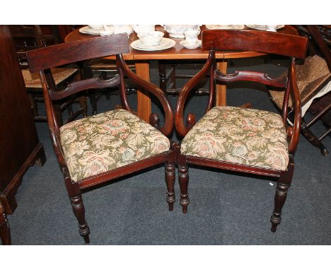 Two Regency mahogany carver dining chairs with curved bar back and scroll arms over tapestry style upholstered drop-in seats,