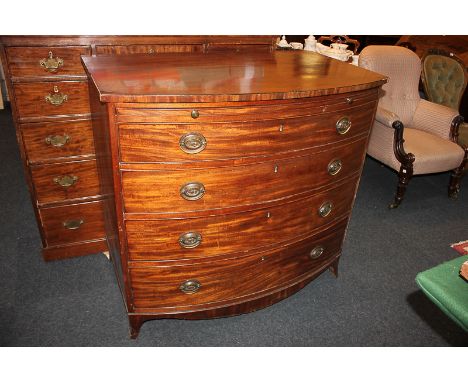 A 19th century mahogany bow front chest of four drawers with pull-out slide and brass drop handles with embossed back plates,