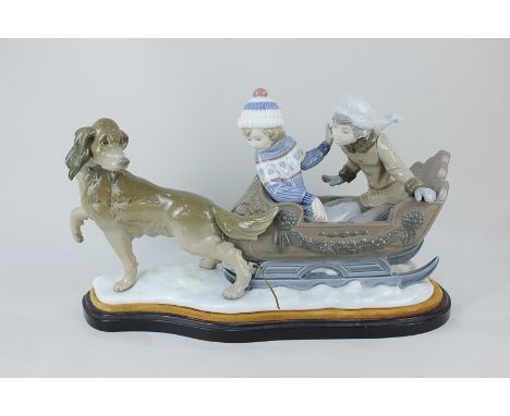 A large Lladro porcelain figure group, 'Sleigh Ride', modelled in the form of two children seated in a sledge being pulled by