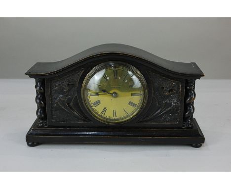 An Arts and Crafts carved oak cased mantel clock, the gilt face marked Weir & Son, Manchester, with Roman numerals and French