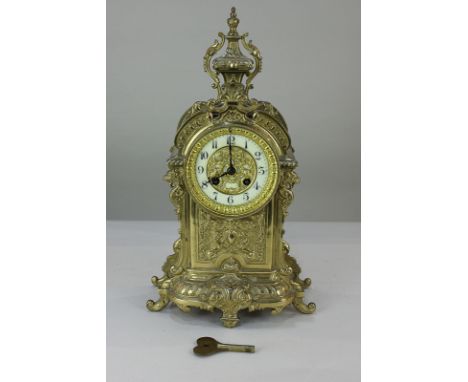 A Louis XVI style ornate French gilt brass mantel clock, with scrolling foliate and rampant lion design, the circular dial wi