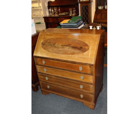 An Edwardian banded mahogany bureau, the drop writing flap with oval inlaid panel enclosing fitted interior, over four gradua