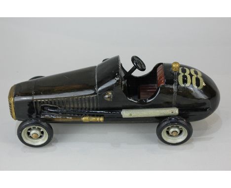 A carved and painted wood model of a vintage car, numbered 88, 27cm long
