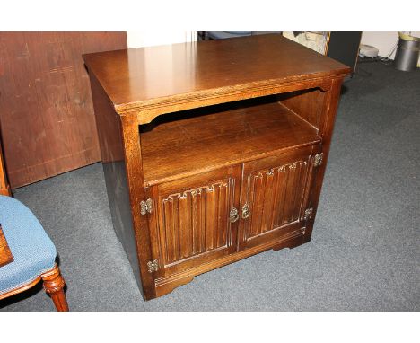 A rectangular oak cabinet with shelf and cupboard below, with linen fold decoration, 79cm