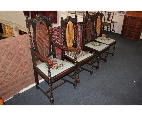 Four Jacobean style oak dining chairs including one carver, each with oval cane panel back over tapestry upholstered seat, wi