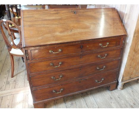 A Georgian mahogany four drawer bureau on bracket feet