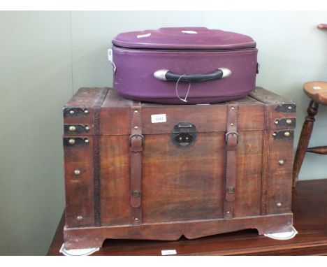 A modern metal bound trunk and a mauve suitcase set