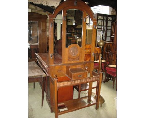 An early 20th century oak hall stand of full height, the raised stepped arched back incorporating a bevelled edged mirror pla