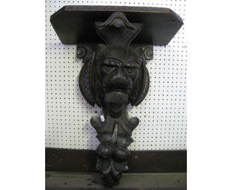 A Victorian oak wall bracket with carved lions mask and trailing fruit detail, 58 cm high approx, the shelf 43 cm wide approx