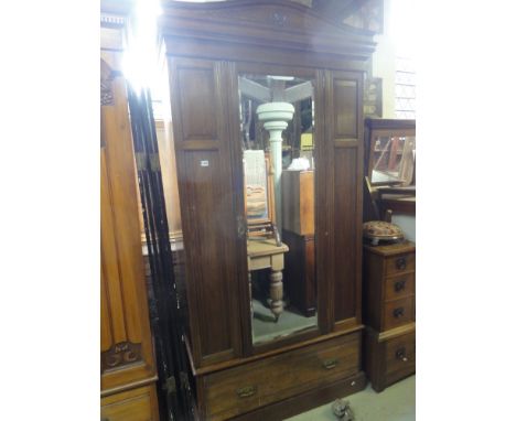 A good quality late Victorian oak wardrobe enclosed by a central three quarter length bevelled edged mirror panelled door fla