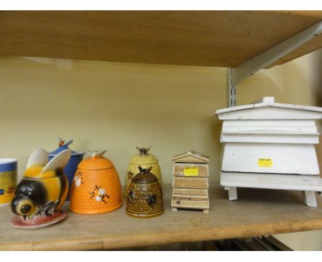 A mixed collection of bee related items including a miniature model of a beehive, a collection of bee related lidded pots inc