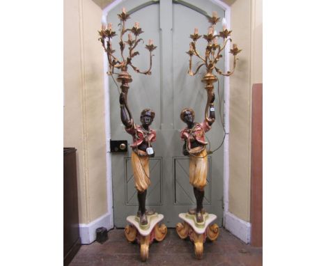 A pair of 20th century floor standing torchieres with character supports raised on tricorn bases with scrolled feet, each buo