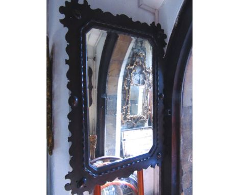An Edwardian oak framed wall mirror with fretted outline and bevelled edged mirror plate.
