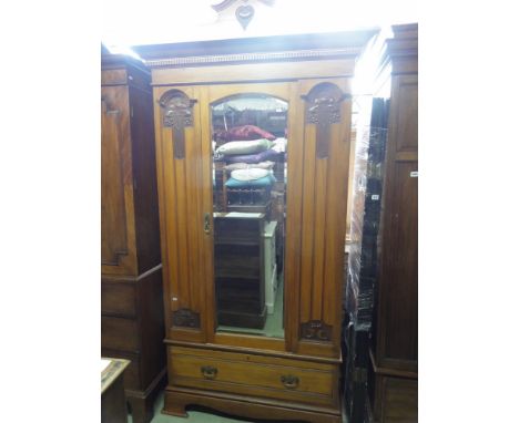 A good example of an Art Nouveau satin walnut single wardrobe enclosed by a central three quarter length slightly arched beve