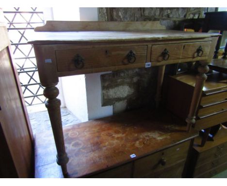 A Victorian stripped and waxed pine side table enclosing two drawers on turned supports together with an upholstered hearth s