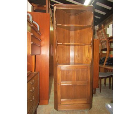 An Ercol Golden Dawn freestanding corner cupboard fitted with two shelves over a single cupboard door enclosing a shelved int