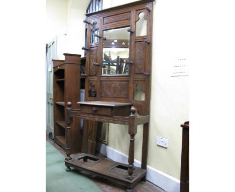 A late Victorian oak hall stand of full height, the raised panelled back with carved shell and foliate detail flanking a rect