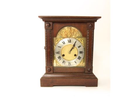 A continental oak case two train mantel clock, with gilt dial with scrolled acanthus panels and mask, 14cm silver chapter rin