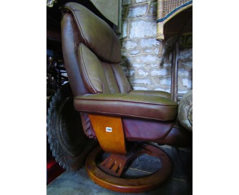 An upholstered armchair with swivel base and simulated leather finish, together with a matching foot stool