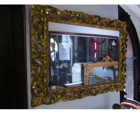 A 19th century Italian carved and gilded mirror frame with pierced detail and acanthus and other scrolled decoration enclosin