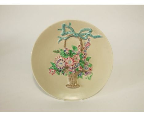 A Clarice Cliff ivory ground charger with high relief moulded and painted flower basket and ribbon detail, with printed mark 