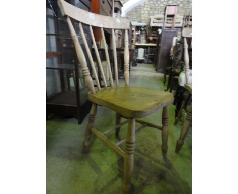 A Harlequin set of four Windsor stick back kitchen chairs in elm and beech, raised on turned supports united by double H shap