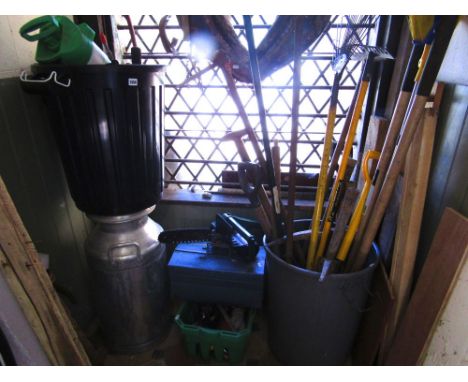 A collection of garden tools, small electric chainsaw, aluminium milk churn, further hand tools, etc.