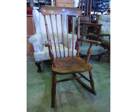 A 19th century Windsor stick back rocking chair in elm and beechwood with waxed finish