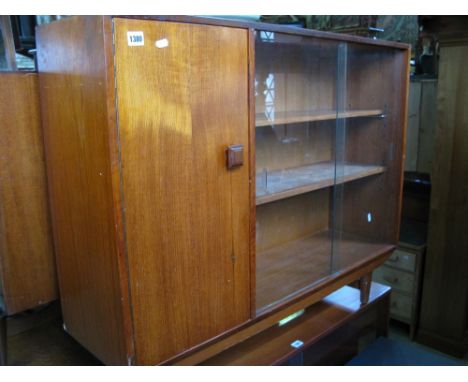 A Danish teak side cabinet fitted with twin sliding glazed doors enclosing a shelved interior, flanked by a single cupboard d