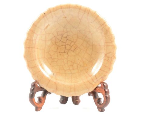 Chinese porcelain small dish, serpentine rim, celadon crackle glaze, diameter 10cm, unmarked, with a hardwood folding stand.Q
