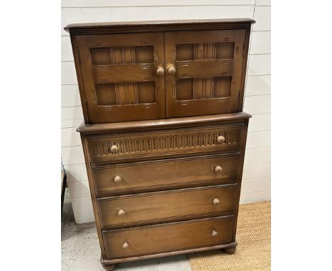 A Mid Century oak drinks cabinet by Priory consisting of four drawers with cupboard over (H123cm W80cm D45cm)