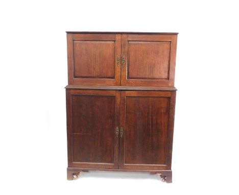 A Georgian mahogany housekeeper's cupboard, with a pair of doors opening to reveal a slide over two further doors, opening to