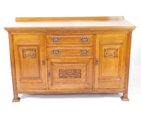 A Victorian Art Nouveau light oak dresser base, with copper plates and brass handles, having two central drawers above a pane