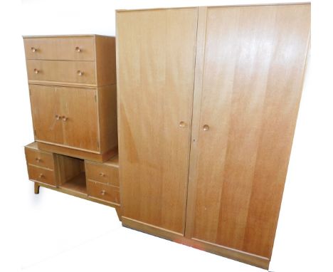 A Meredew mid 20thC light oak bedroom suite, comprising double wardrobe, 176cm high, 123cm wide, 53.5cm deep., a linen press 