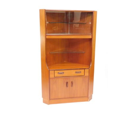 A G-Plan teak corner unit, with a pair of glazed doors, enclosing a mirrored shelf, and two removable glass and wooden shelve