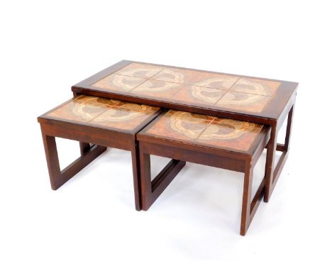 A vintage mahogany tile top nest of occasional tables, set with orange and brown tiles in a geometric cloud design, raised on